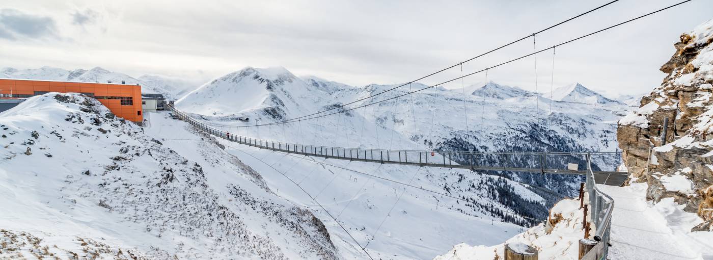 Verschneite Bergstation mit Hängebrücke